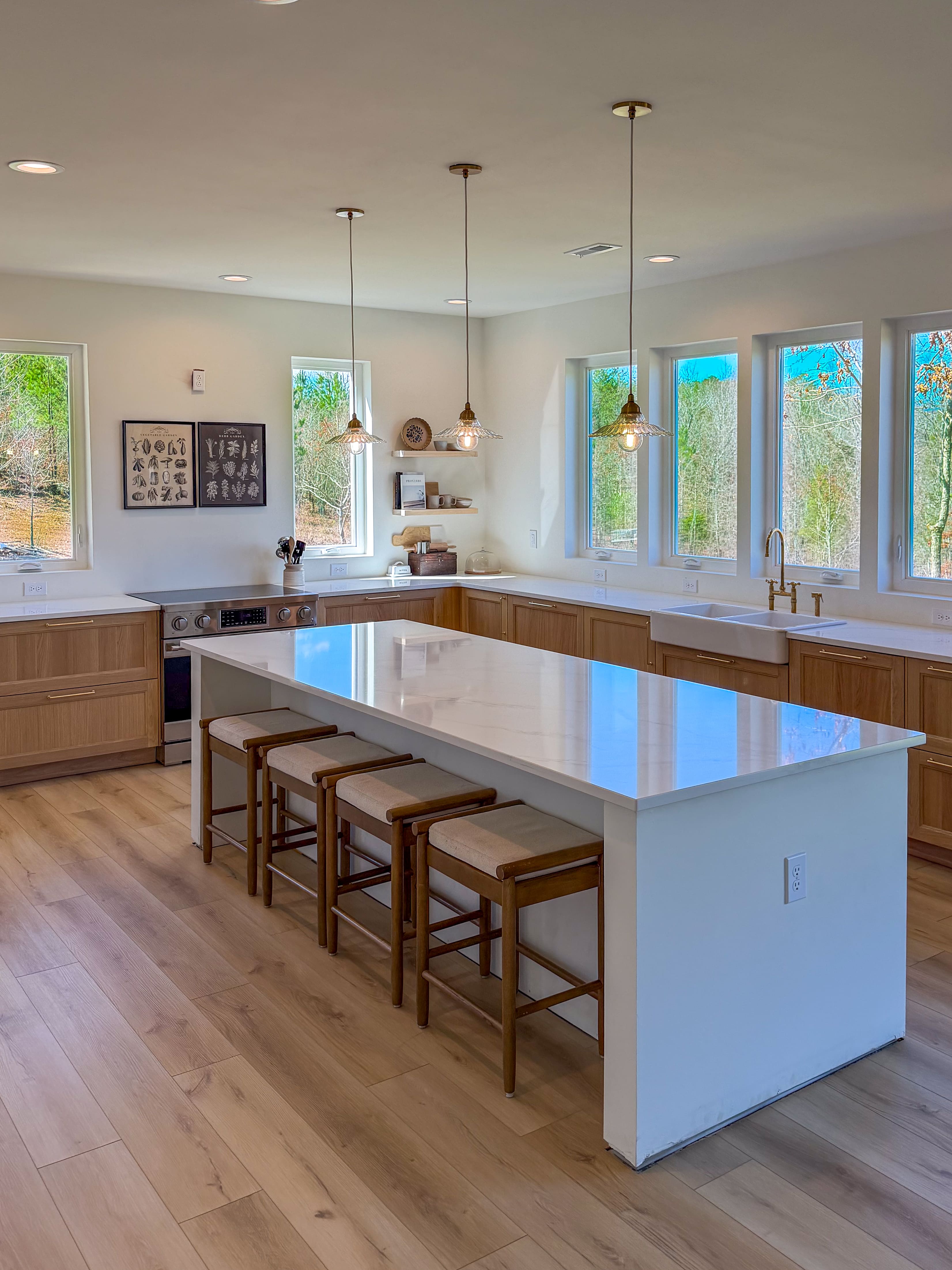 MATERIAL: 3CM CALACATTA VIOLA. A bright, airy kitchen with natural wood tones and clean white surfaces. Large windows and soft finishes create a warm, minimal space designed for everyday living.