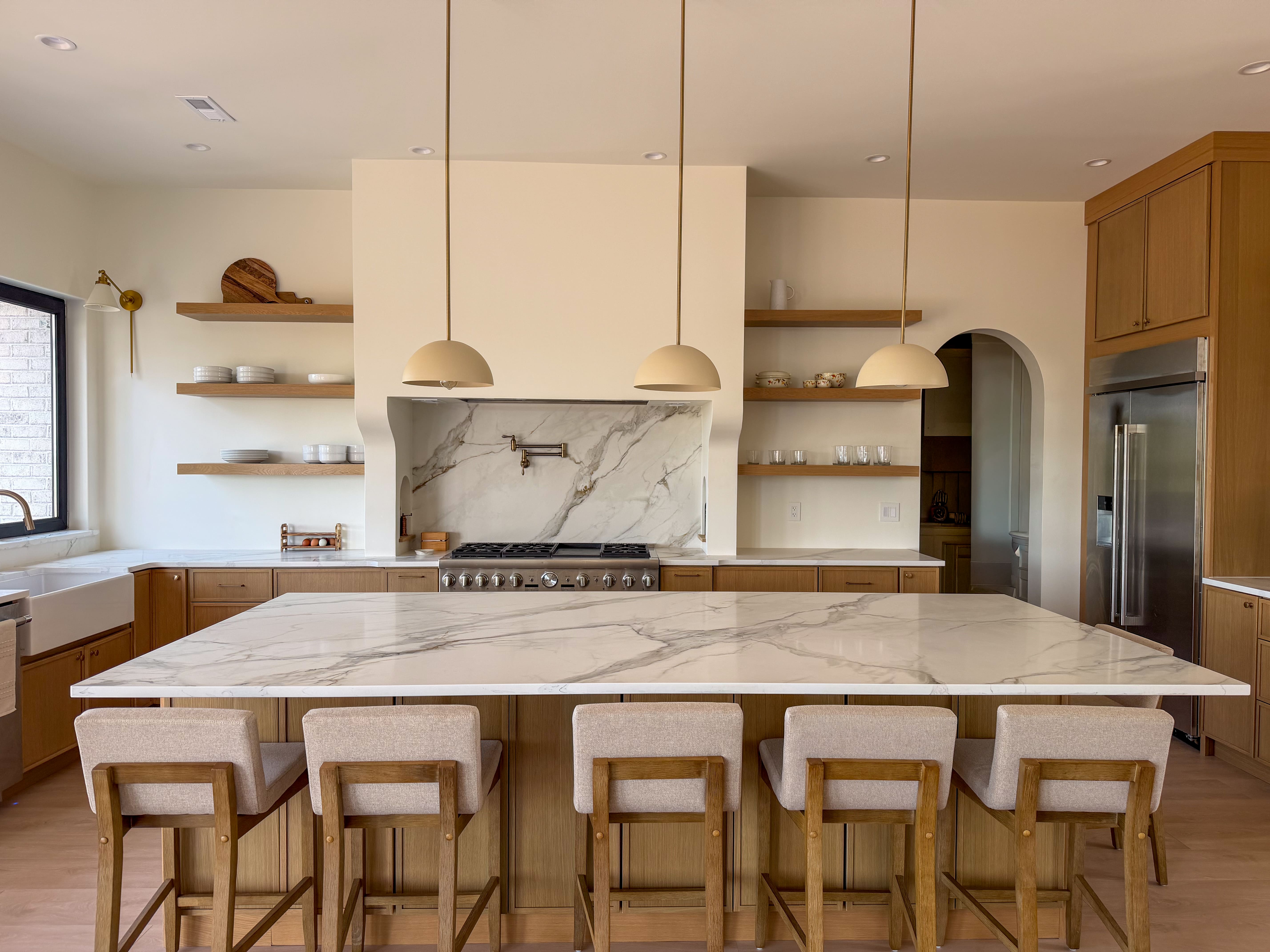 This kitchen features a full custom installation in 3CM Calacatta Royale Quartz, including perimeter countertops, full backsplash, island, and window sill. The bright white stone pairs beautifully with natural wood cabinetry, creating a clean, warm, and modern look with a timeless luxury feel.