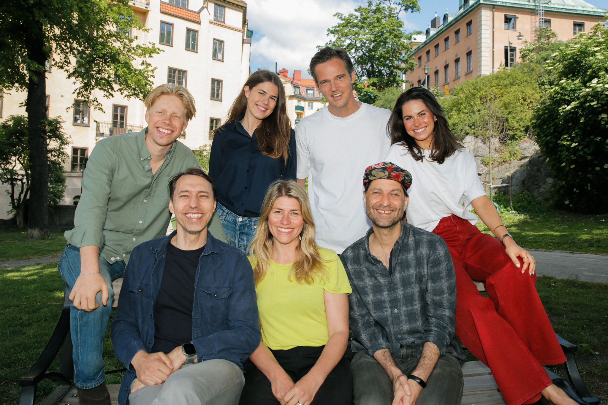 Norrsken Evolve team, sitting on a bench in a park, smiling
