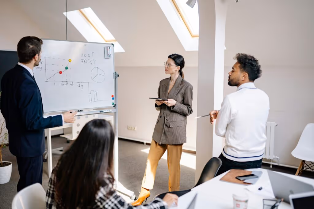 Team discussing data insights. AI tools like ChatGPT or Gemini can support this process by generating summaries, highlighting patterns, and preparing talking points before meetings.