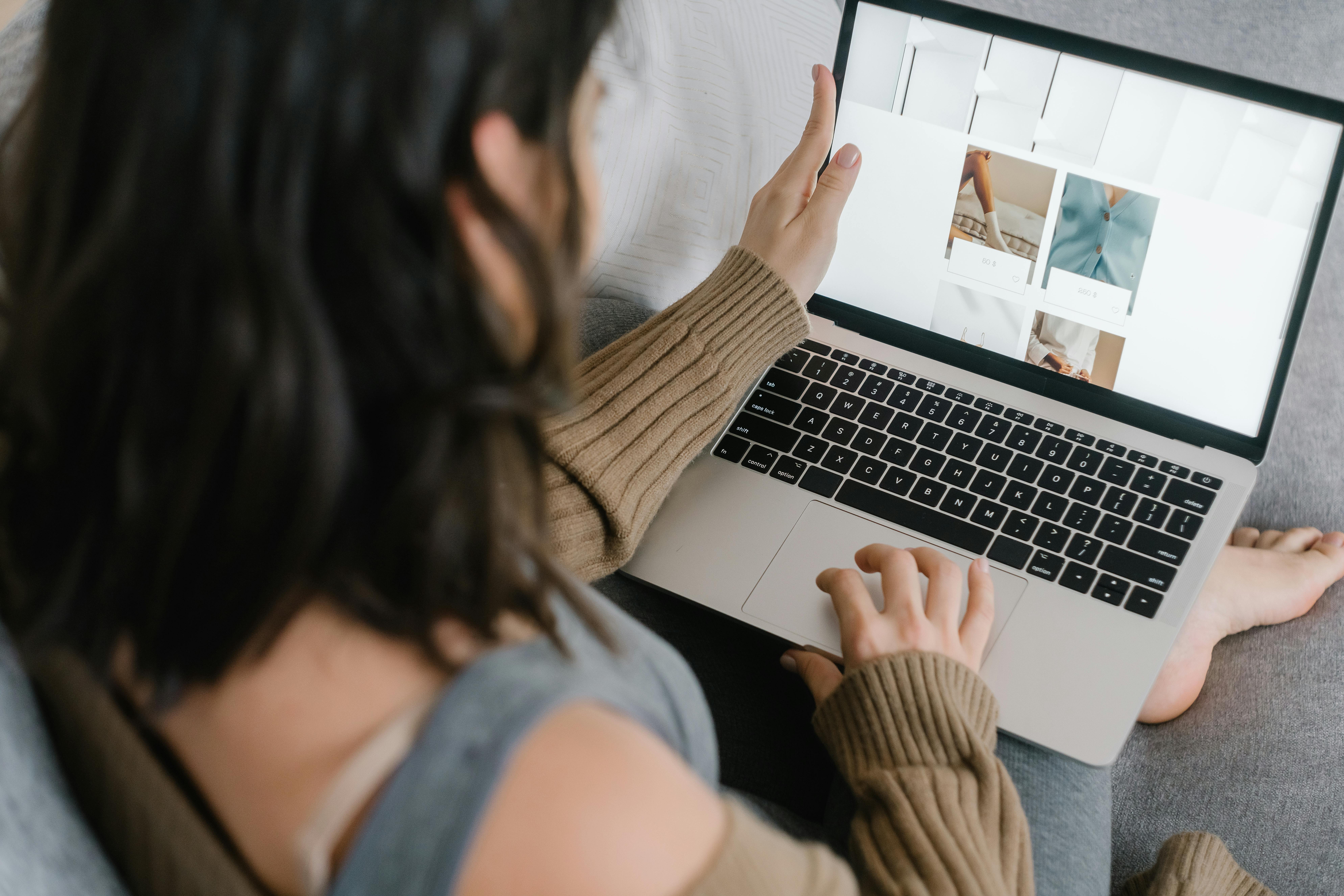 A person browsing through a laptop screen, related to improving UX/UI for higher conversions in digital marketing.