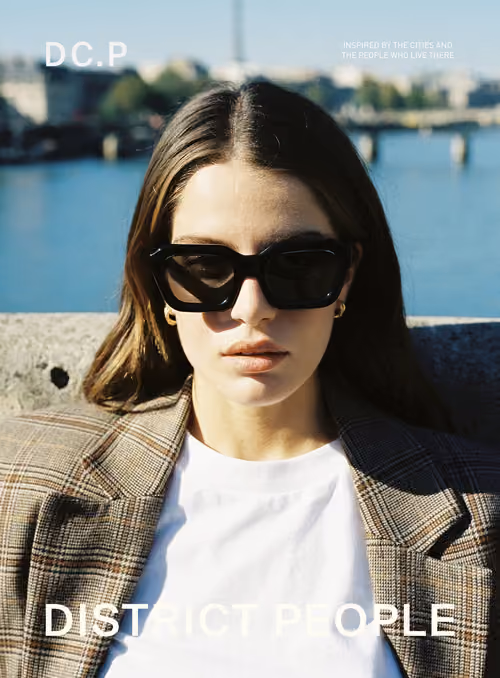 District People campaign poster: woman in sunglasses by the Seine in Paris