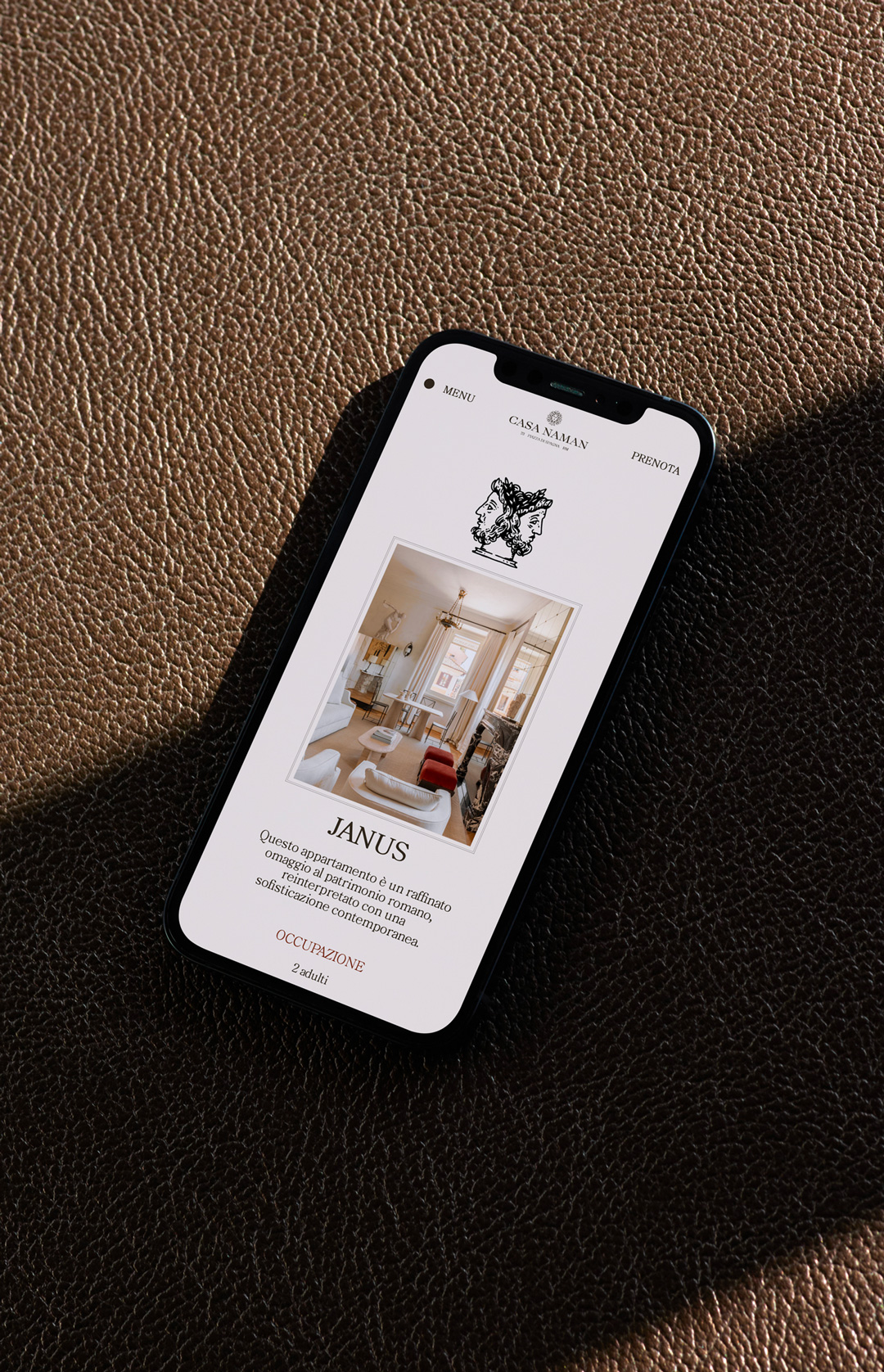 Casa Naman website on a phone resting on brown leather