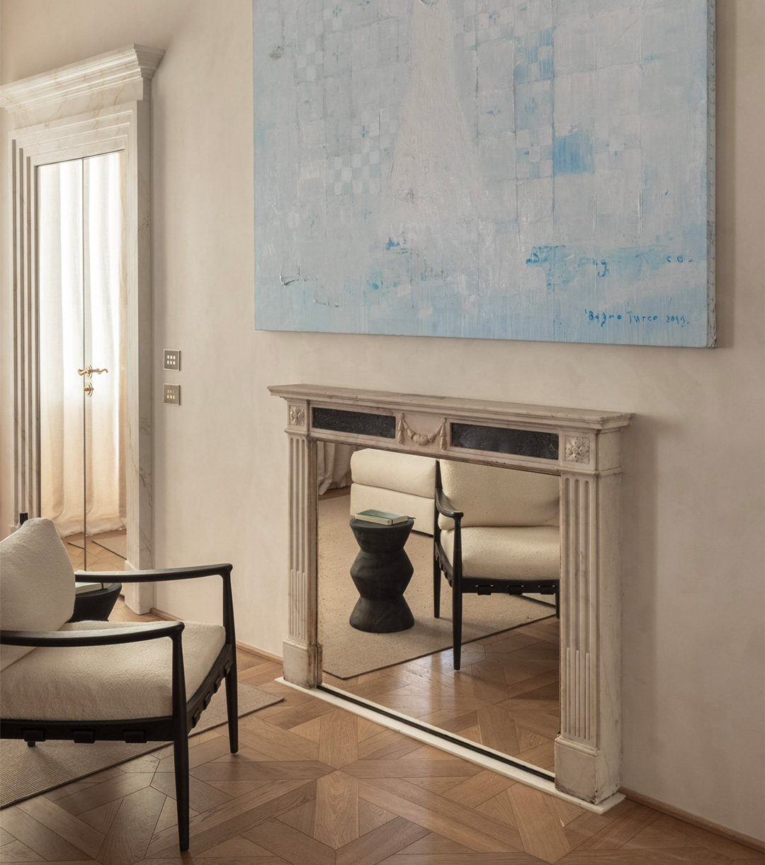 Casa Naman: blue painting above a marble fireplace with a mirror