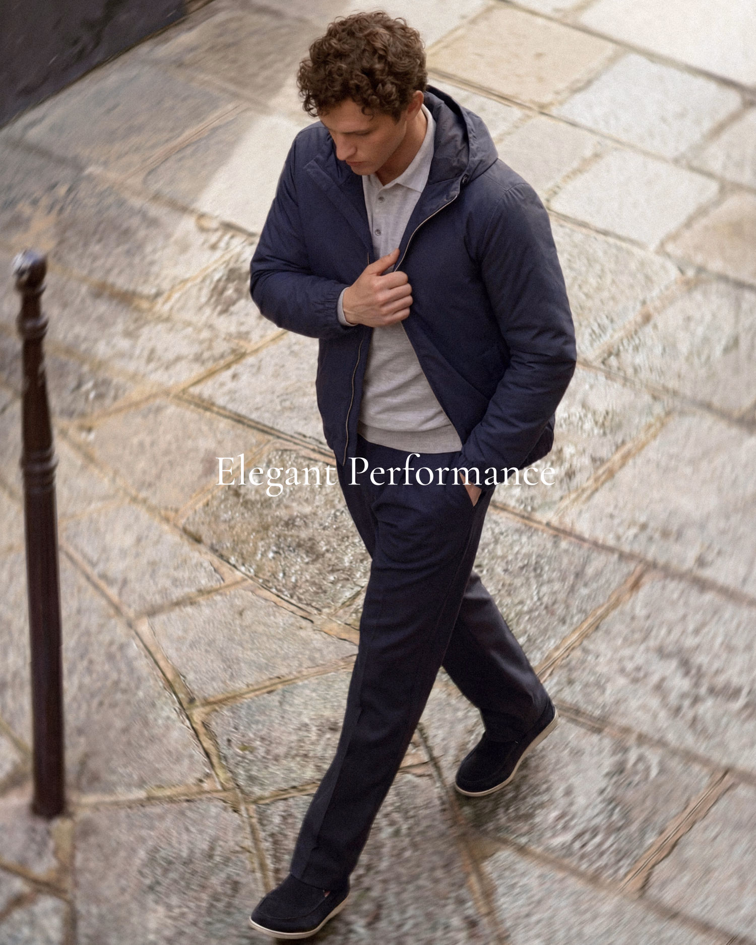 Paul & Shark FW26: man in a navy hooded jacket walking on a cobbled path