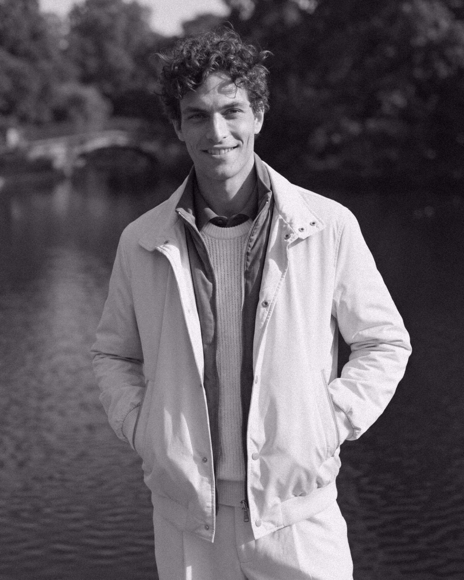 Paul & Shark FW26: black and white portrait of a smiling man in a white jacket by a lake