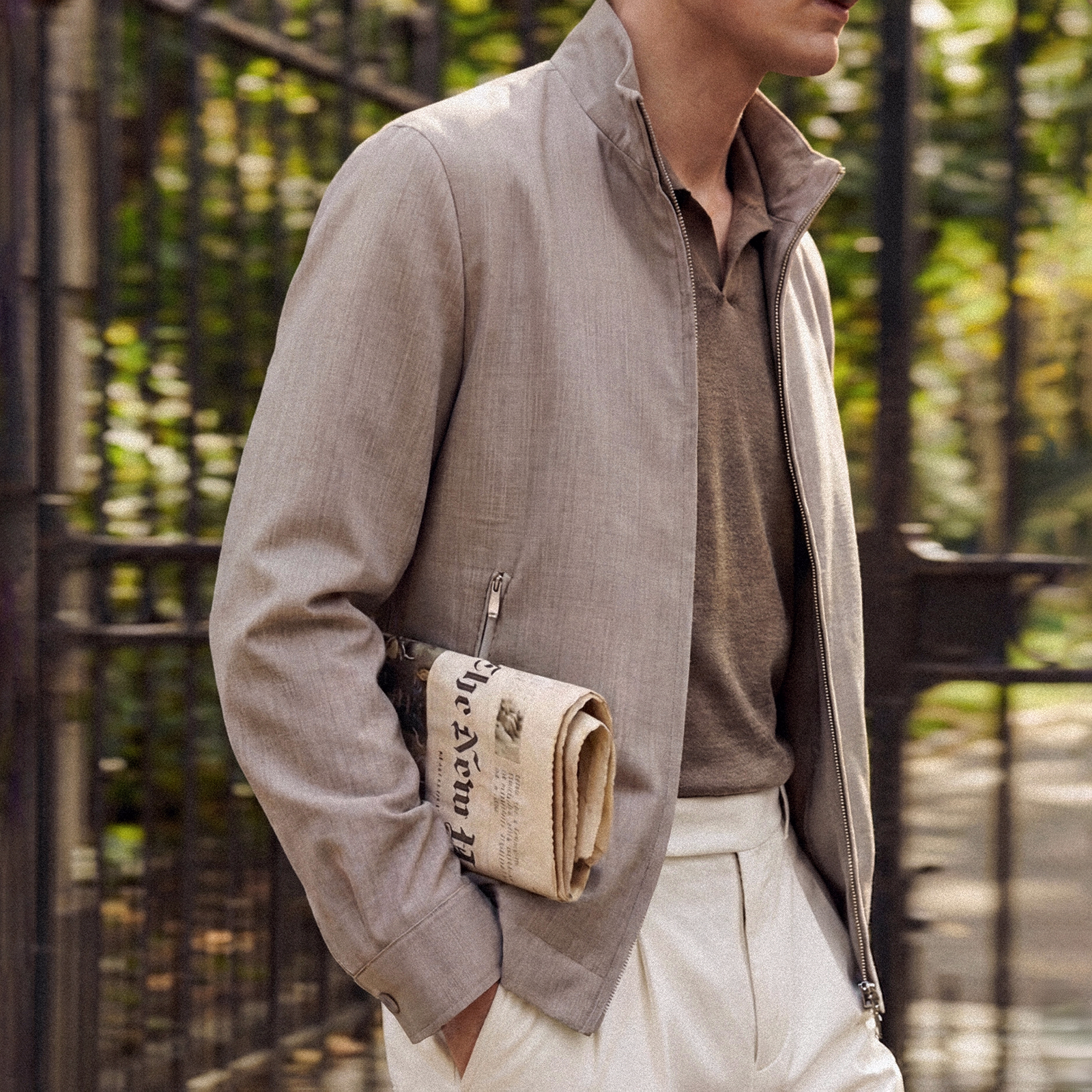 Paul & Shark look: man in a beige jacket holding a newspaper