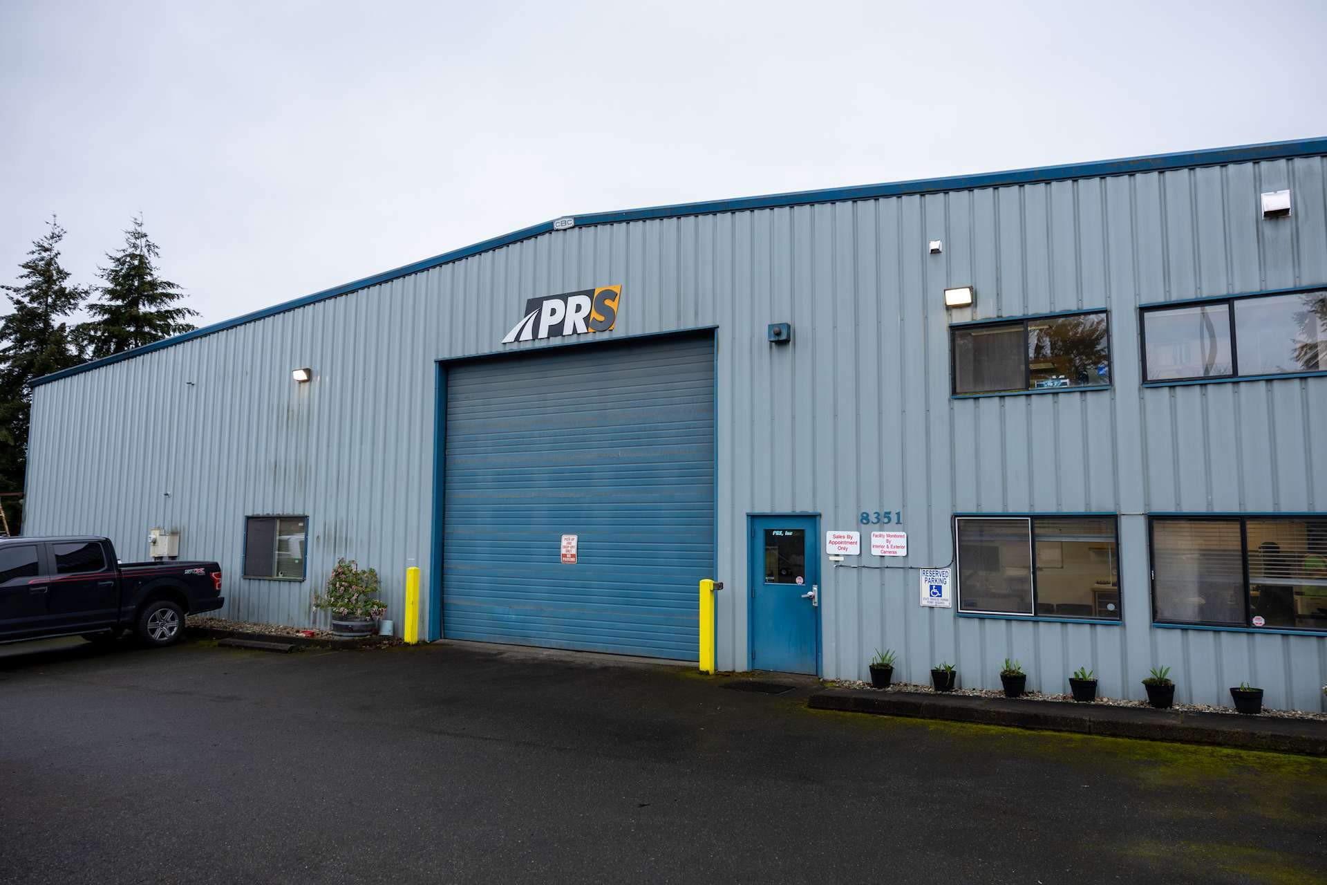 Exterior of PR Systems headquarters in Puyallup, WA, showcasing industrial metal building and company signage.