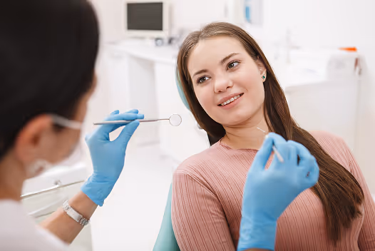Dentist talking to female patient during dental checkup.