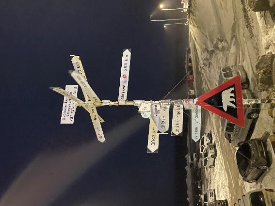 A street sign with many signs on itDescription automatically generated