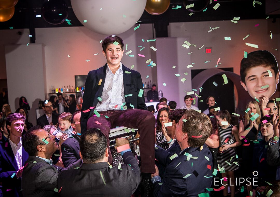kid being lifted on a chair to dance at his mitzvah