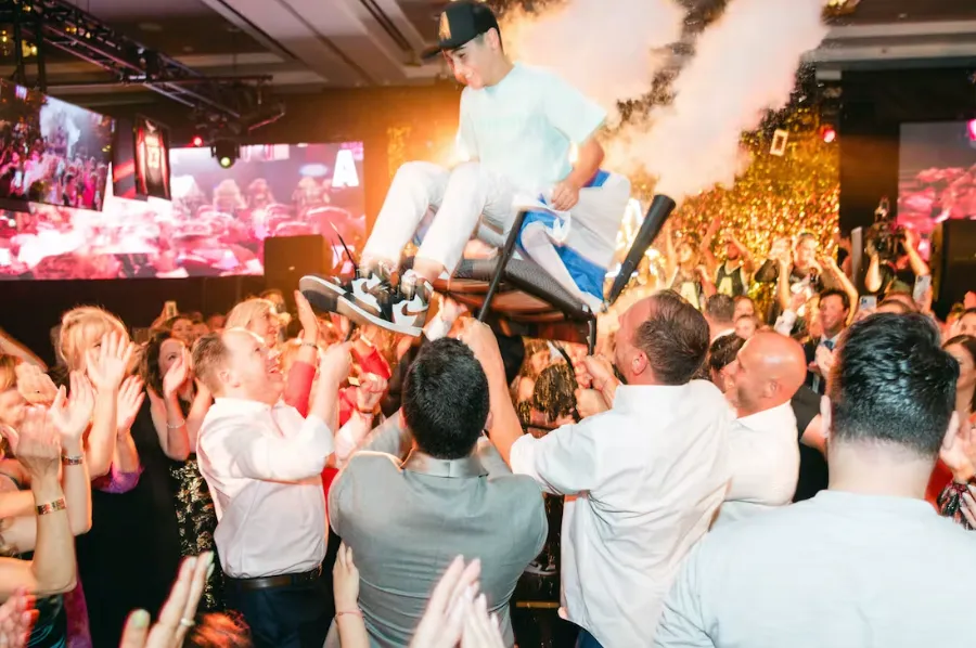kid being lifted on a chair at his mitzvah