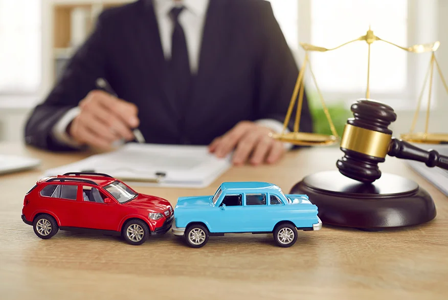 A image of two car toys and a lawyer in the background.