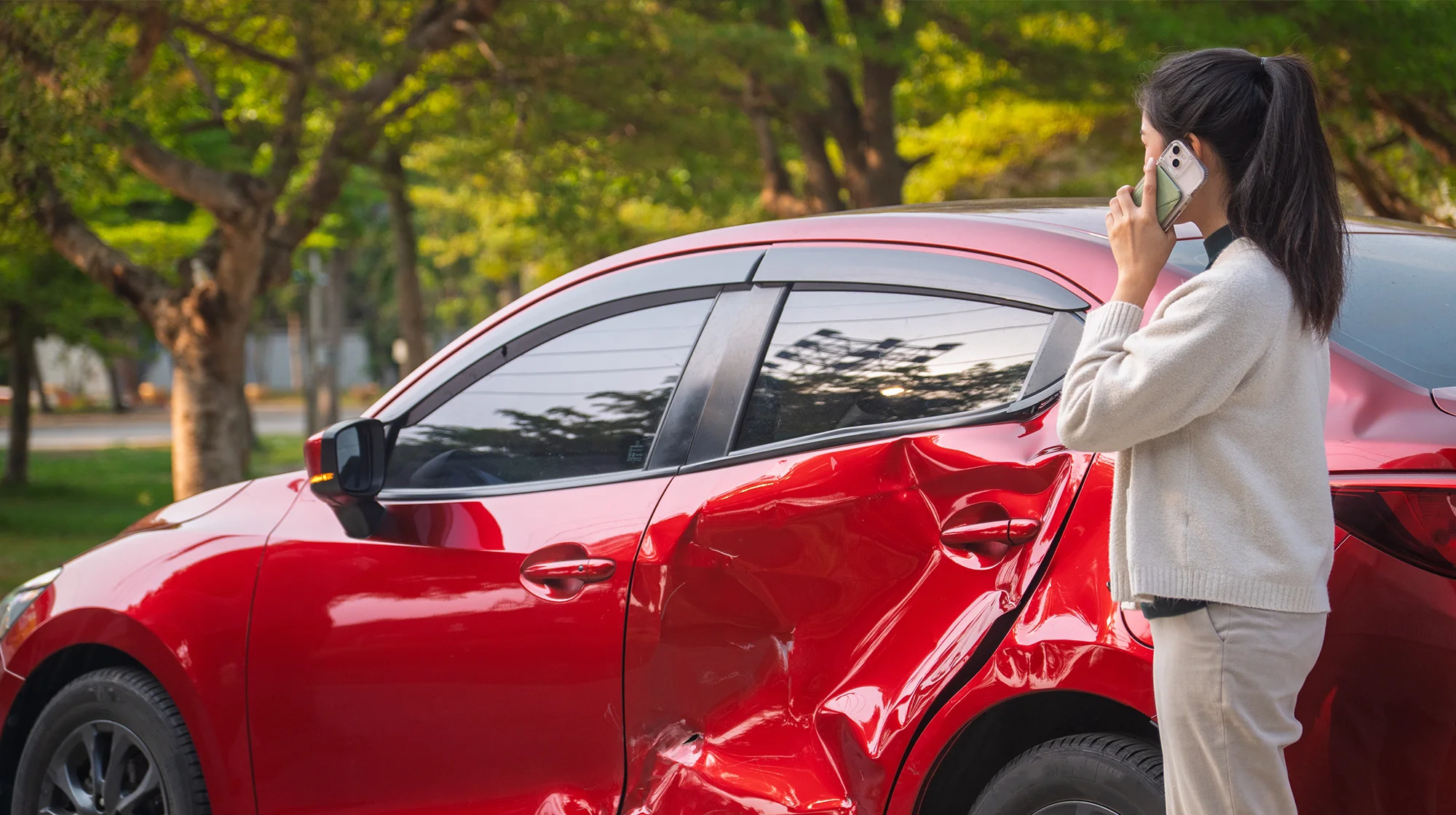 A woman talking on the phone after an car accident.