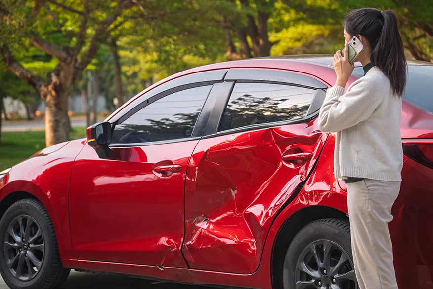 A woman talking on the phone after an car accident.