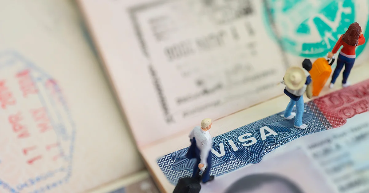 Figuras en miniatura en una visa en pasaporte.