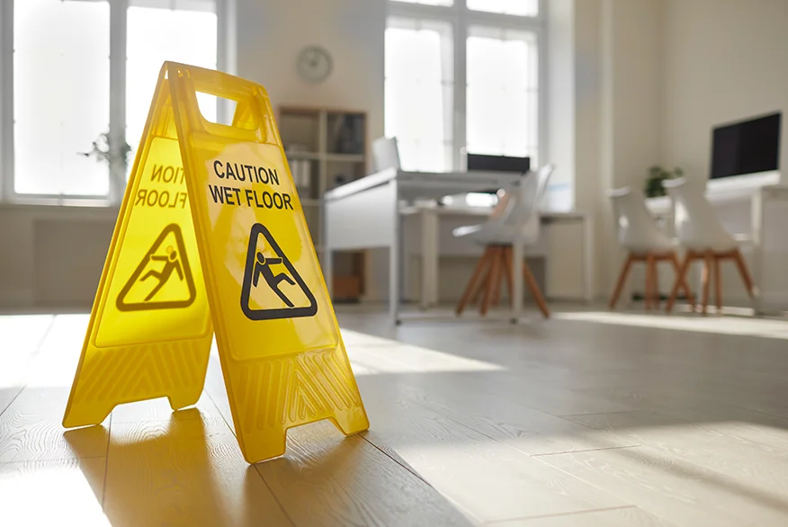A yellow sign with inscription "Wet Floor" on the floor.