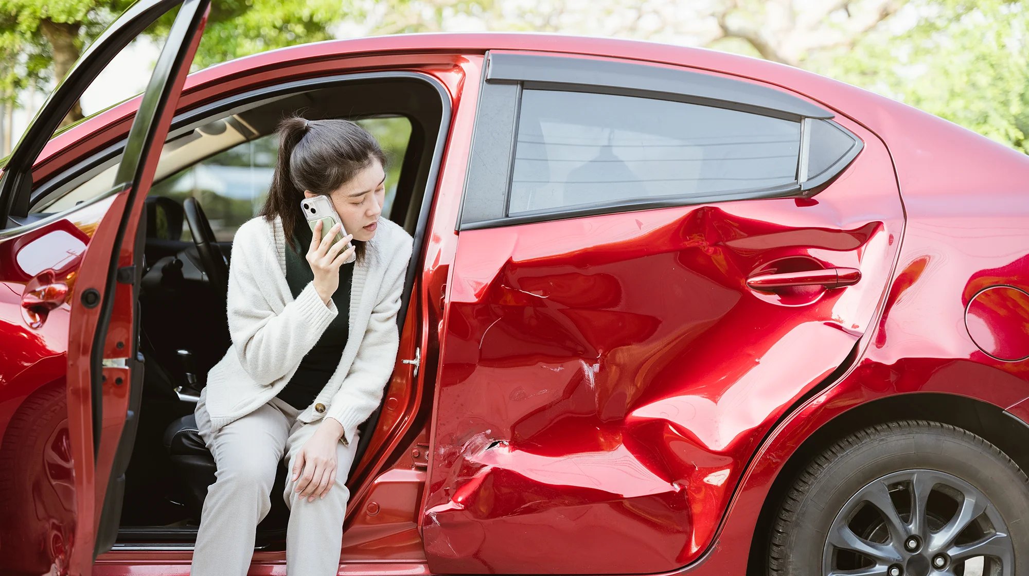A woman talking on the phone after an accident.