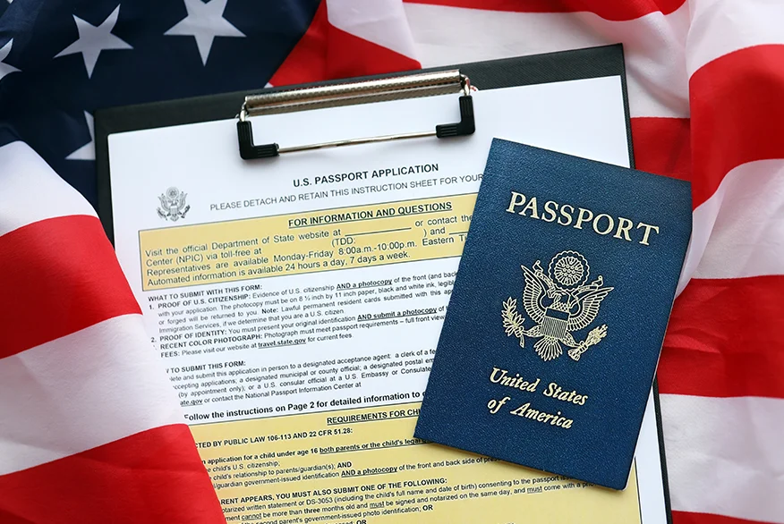 US Passport over passport application and US flag.