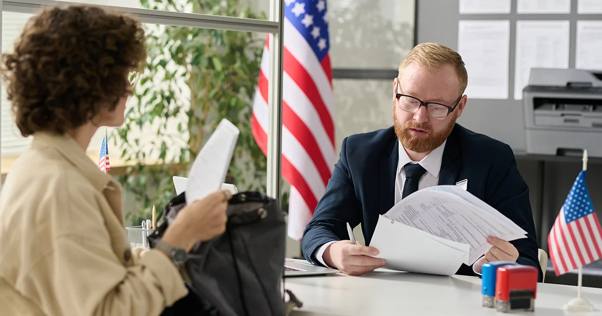 Un hombre revisando documento presentado por una mujer durante una entrevista.