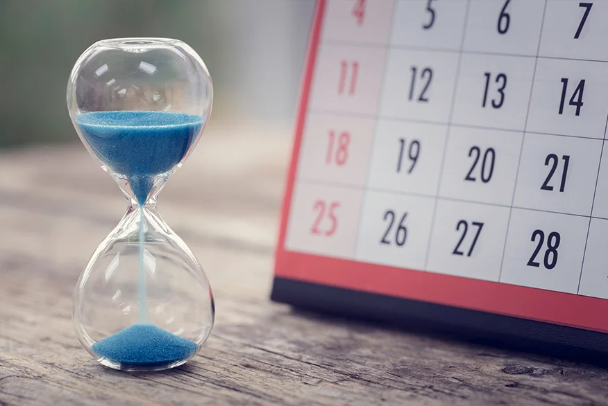 Hour glass with a calendar on the background.