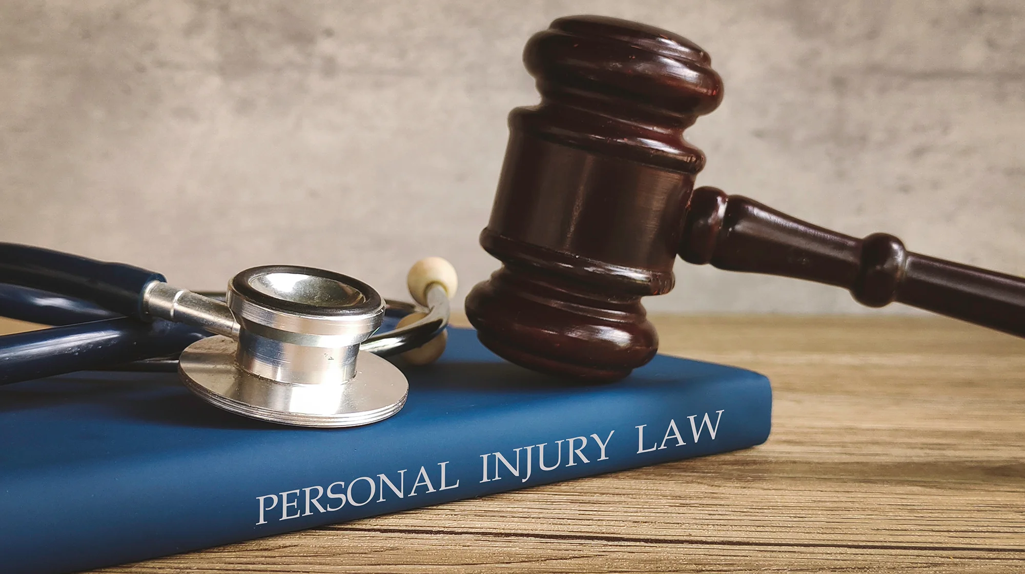 Gavel and stethoscope on a book titled "PERSONAL INJURY LAW," symbolizing legal action for medical issues.