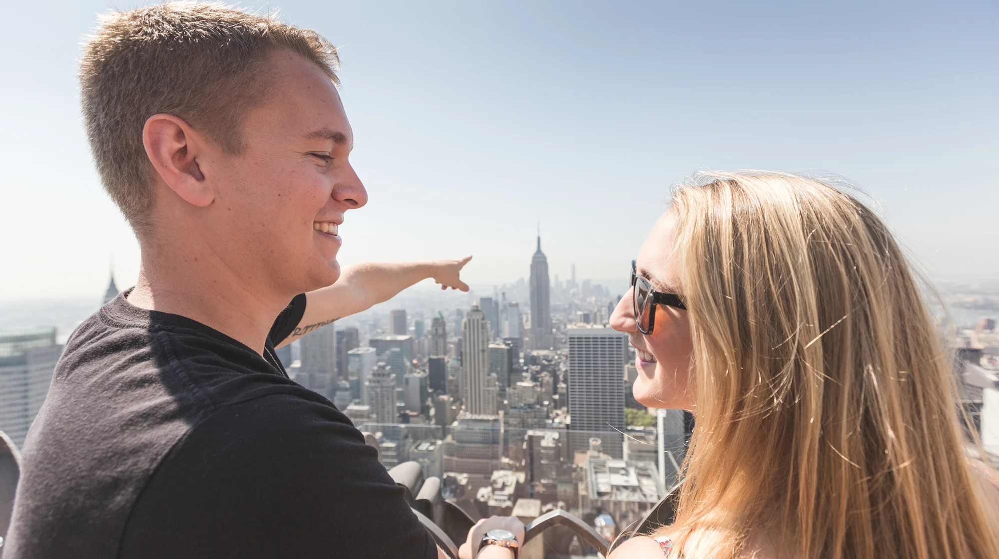 Una joven pareja feliz viendo el Empire State Building en Nueva York.