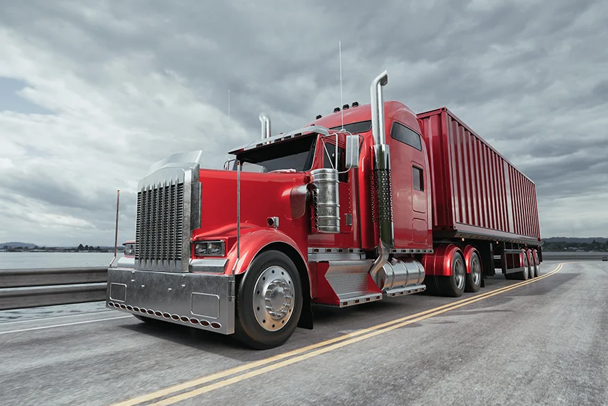 A red classic semi truck driving on the road.