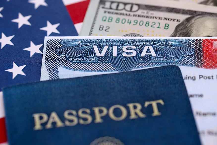 Close up picture of US Visa with dollars in the background.