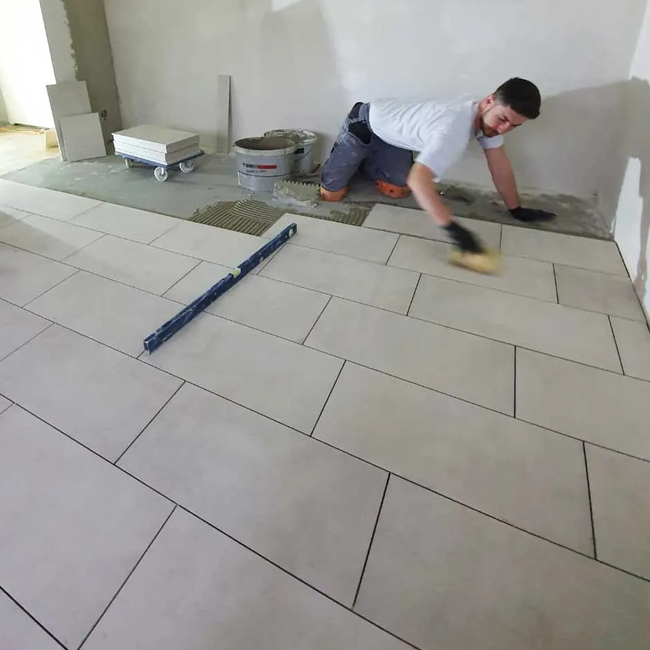 Elvedin Vejseli beim Verlegen von Bodenplatten