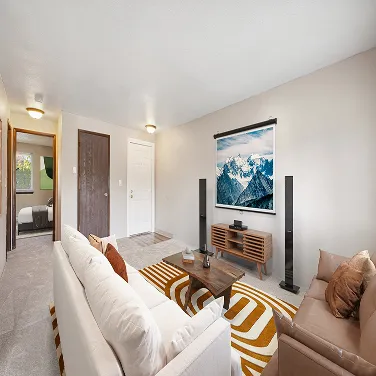 Cozy mid-century living room with white and brown sofas, wood coffee table, and mountain scenery projector screen.