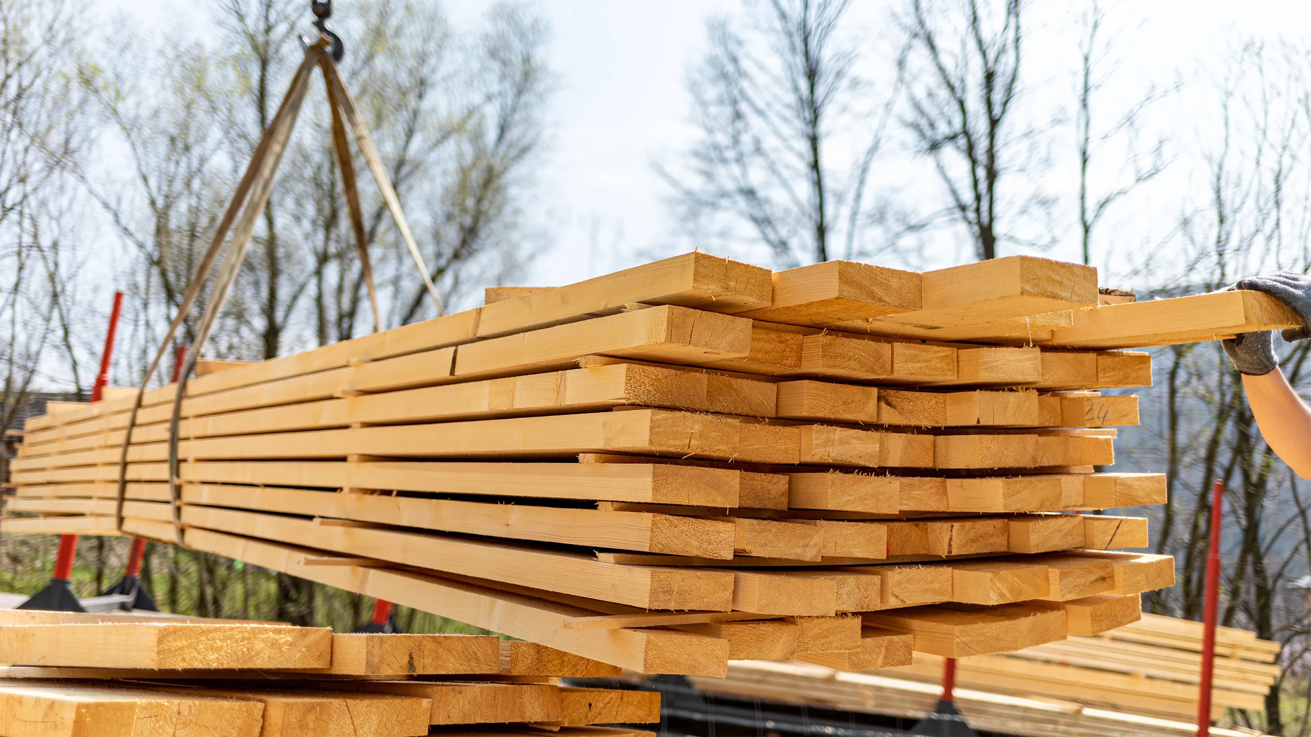 Unloading wooden beams from a truck on a construction site