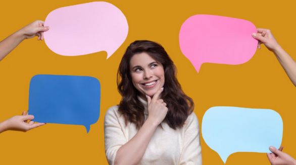 Une femme tenant quatre bulles de dialogue colorées, symbolisant la communication et l'échange d'idées.