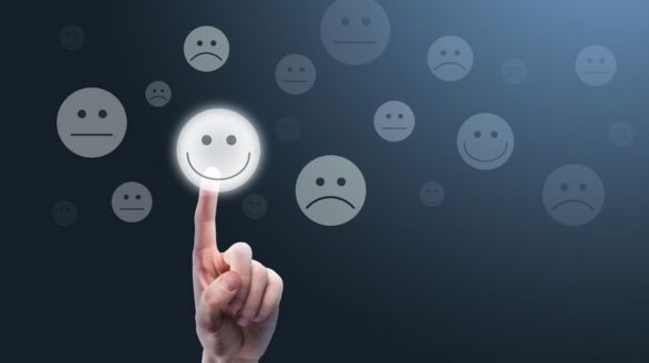 Une personne touche un visage souriant avec un doigt.