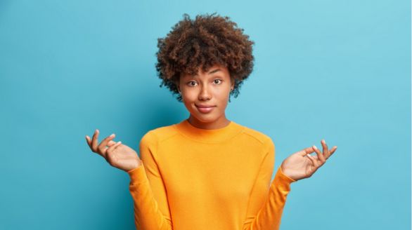 Femme afro-américaine jeune, souriante, avec la main ouverte, exprimant l'accueil ou la disponibilité.