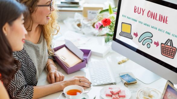 Deux femmes regardent un écran d'ordinateur affichant les mots "acheter en ligne".