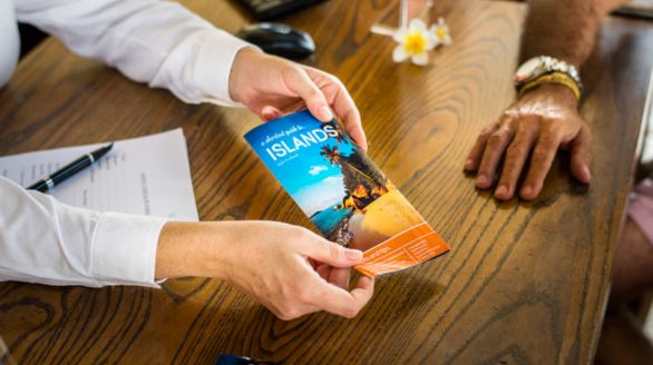 Un homme remet une brochure à un autre homme dans un cadre informel.