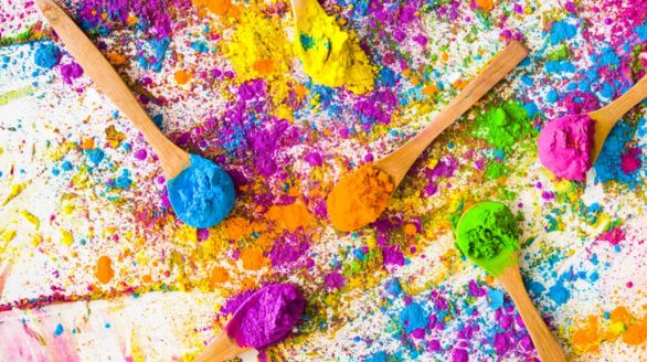 Peinture colorée éclaboussée sur un fond blanc, créant un effet artistique vibrant et dynamique.