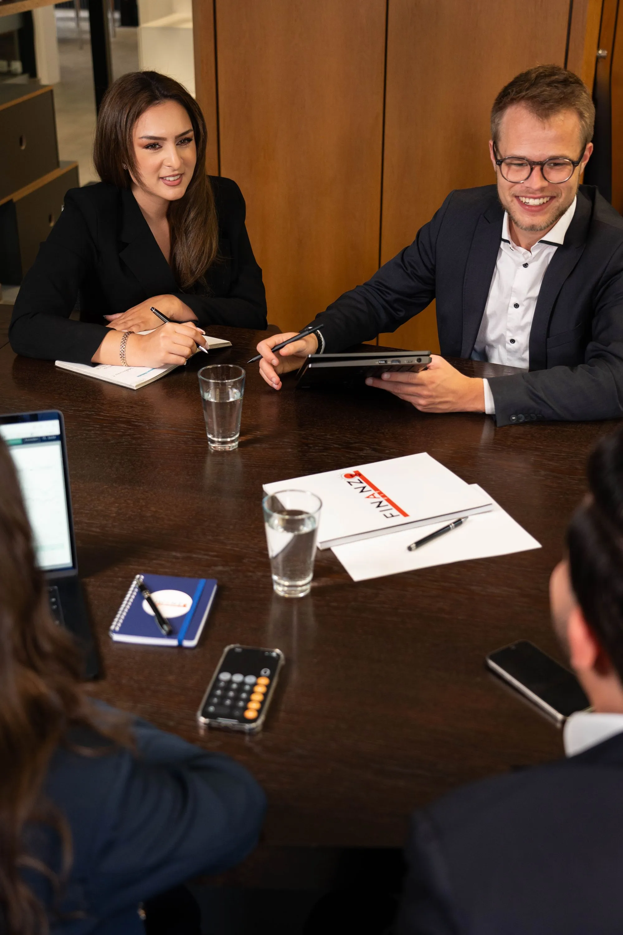 2 people from finanzfit are sitting on a table and talking 