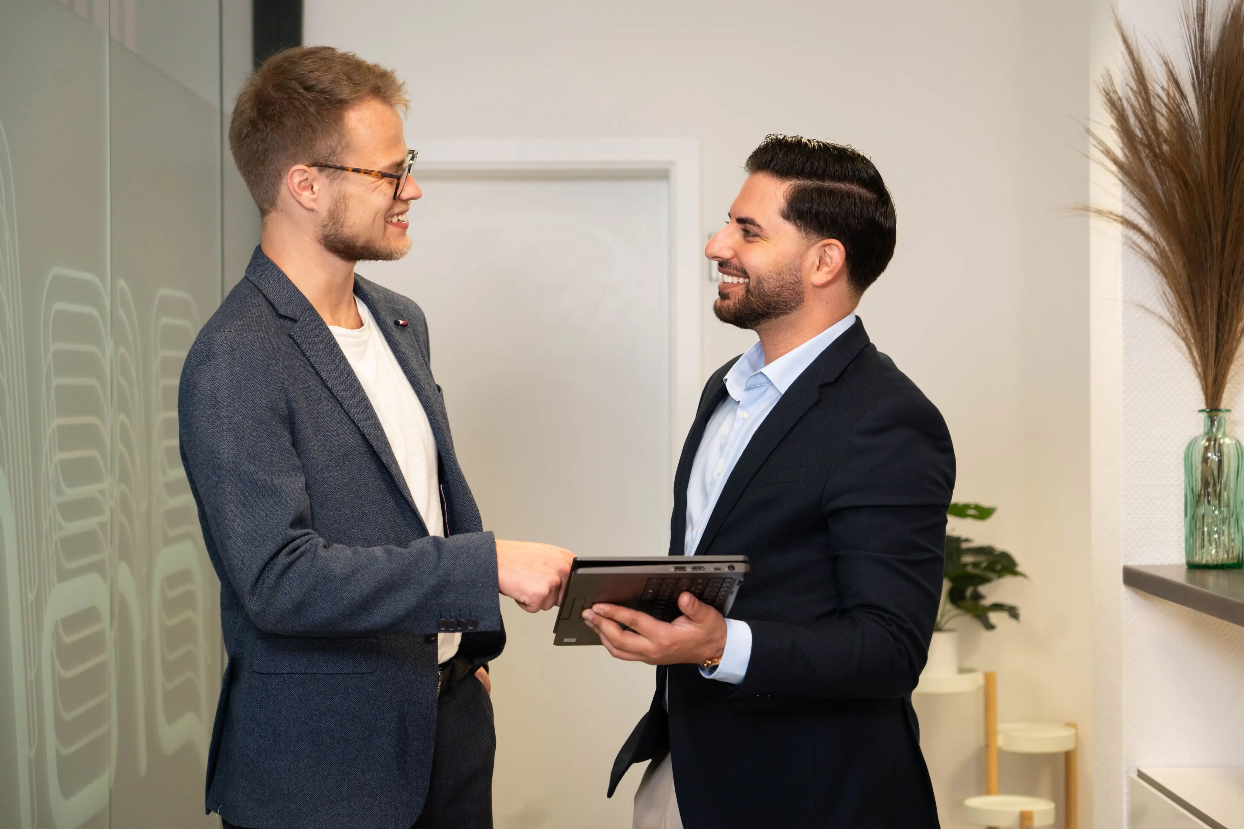 Nasim Birawi und Tim Einck besprechen Finanz- und Immobilienstrategien im Büro.