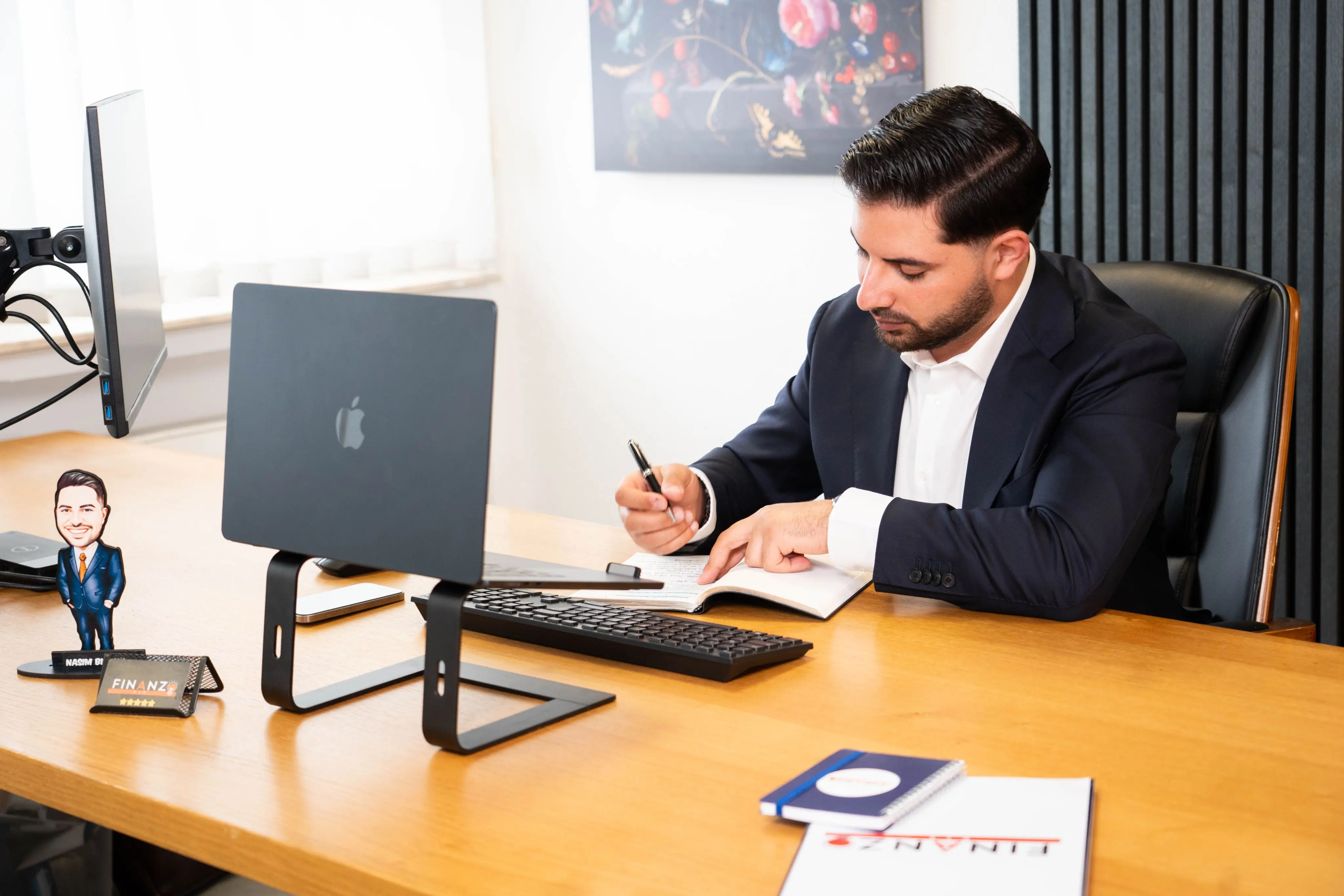 Nasim Birawi checkt Kunden-Unterlagen und schreibt Notizen.