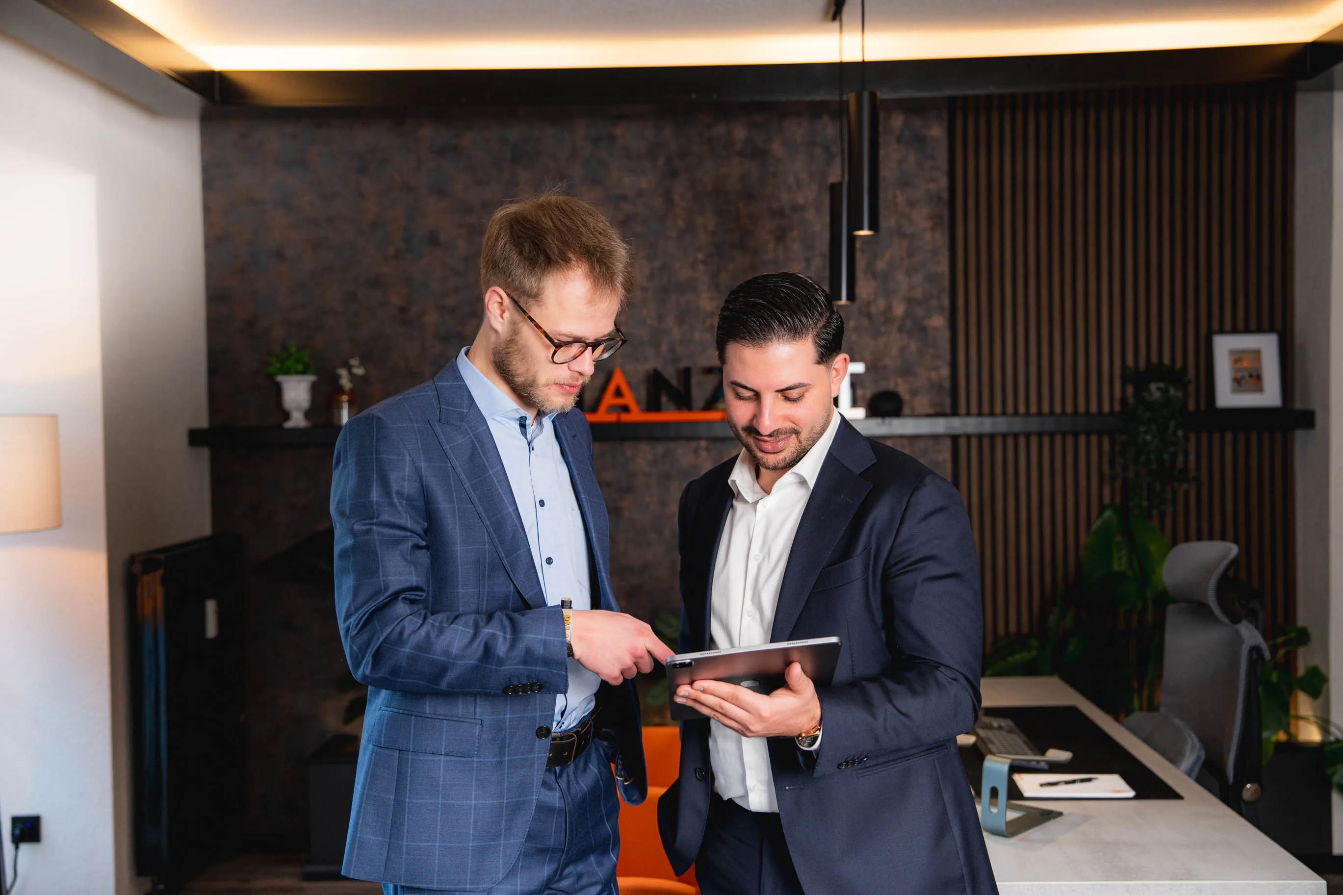 Tim und Nasim betrachten gemeinsam Daten auf einem Tablet.