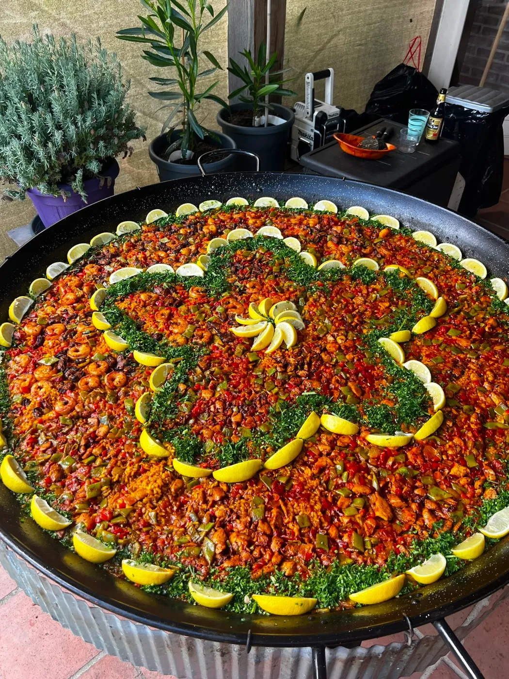 Paella met een bloem van citroen en peterselie op een borrel