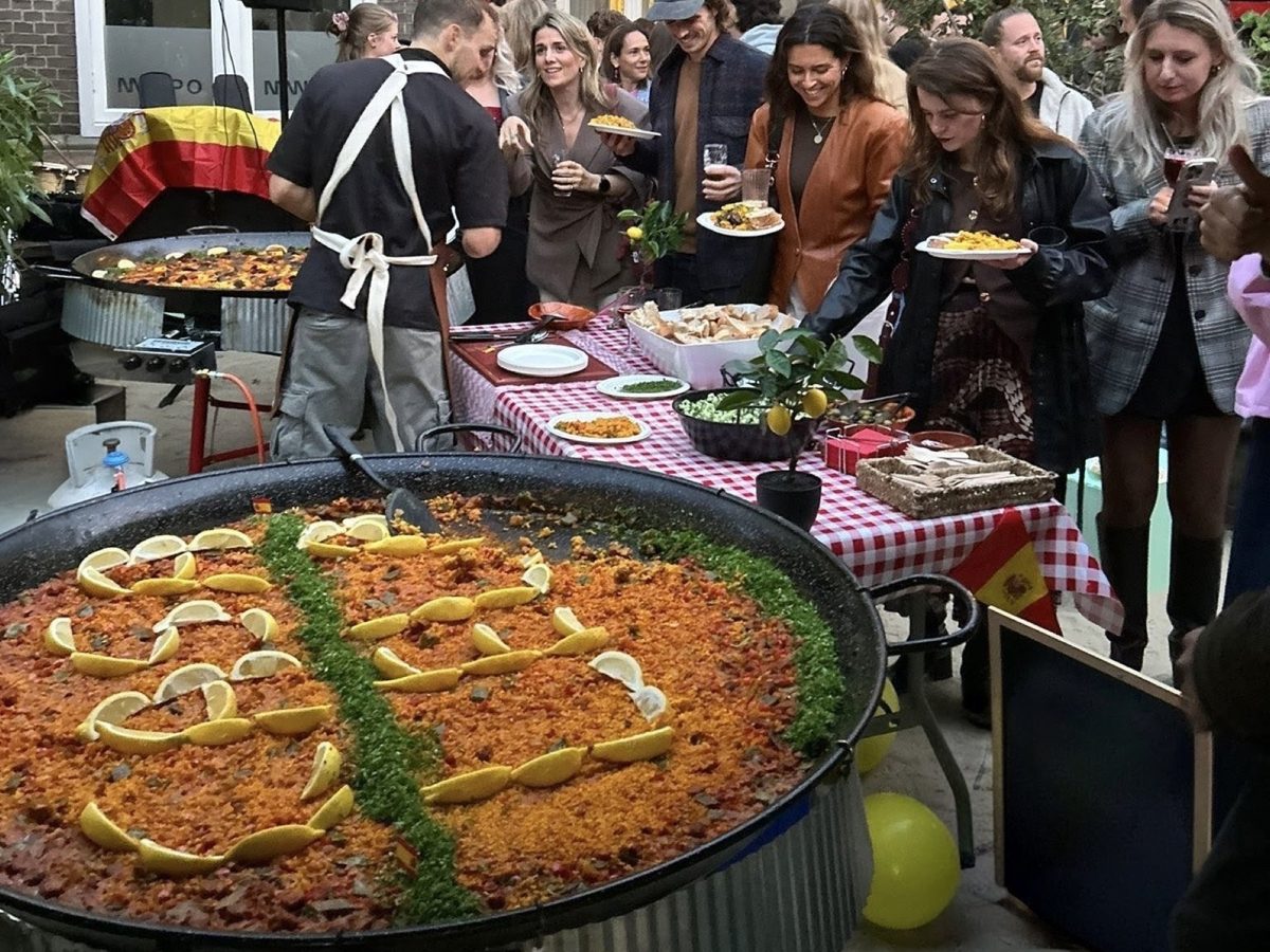 Gasten scheppen op bij een tuinfeest met Spaanse vlaggetjes