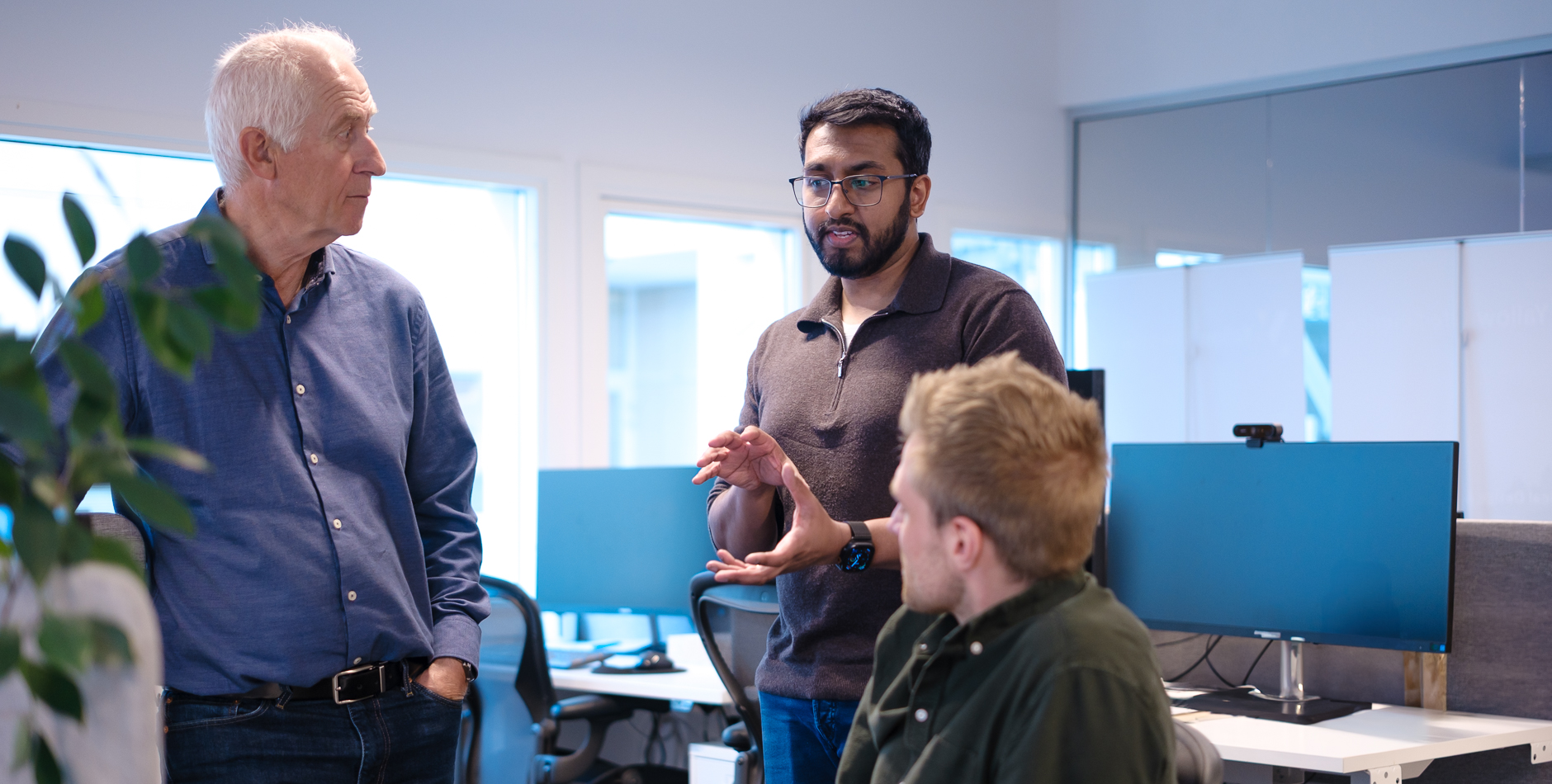 Three men having a discussion in an office