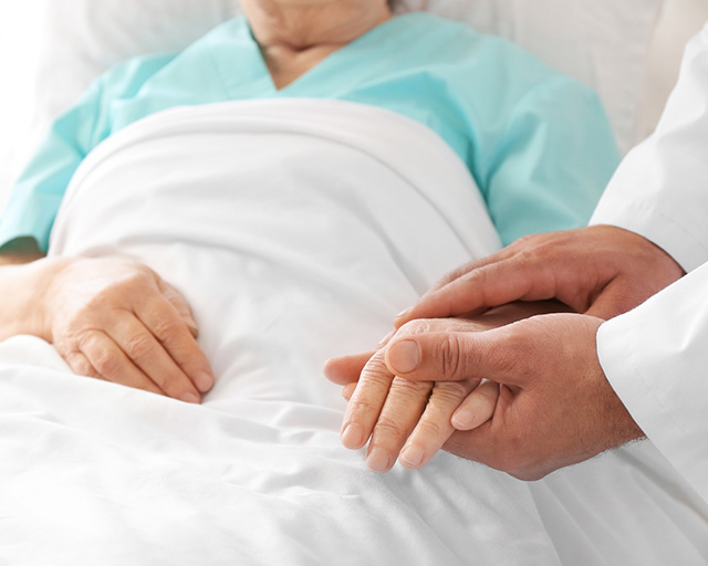 A doctor holding a patients hand