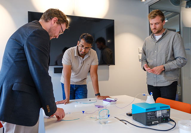 Three men testing a vacuum pump