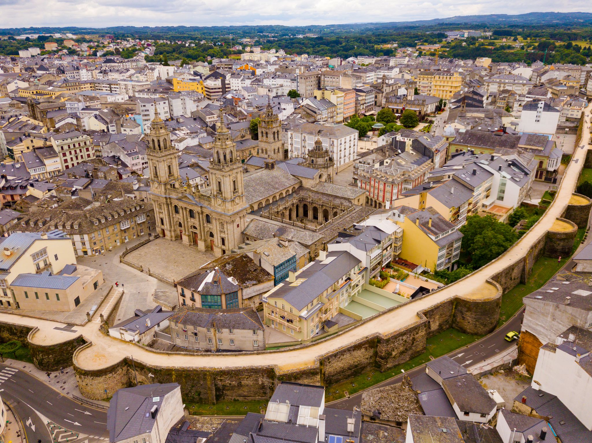Aerial view of Lugo city center with the ancient Roman walls surrounding buildings and a prominent historic cathedral.