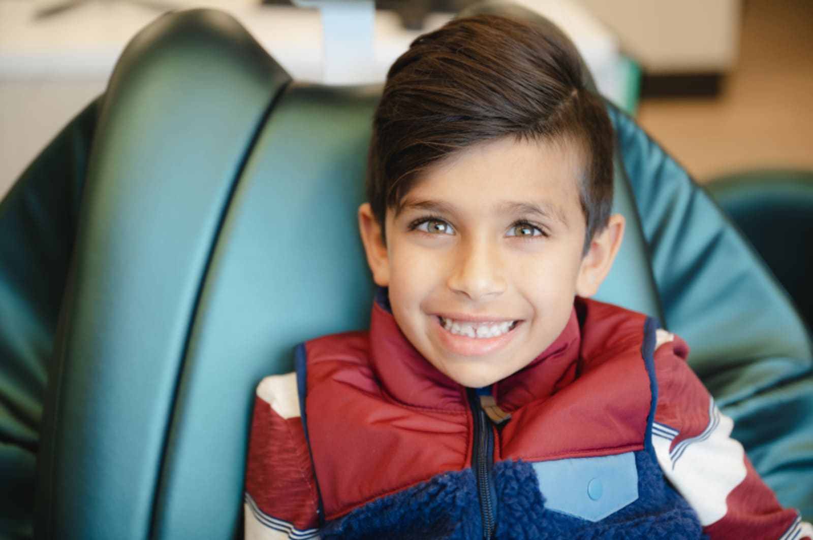 Young boy smiling in dental chair during appointment