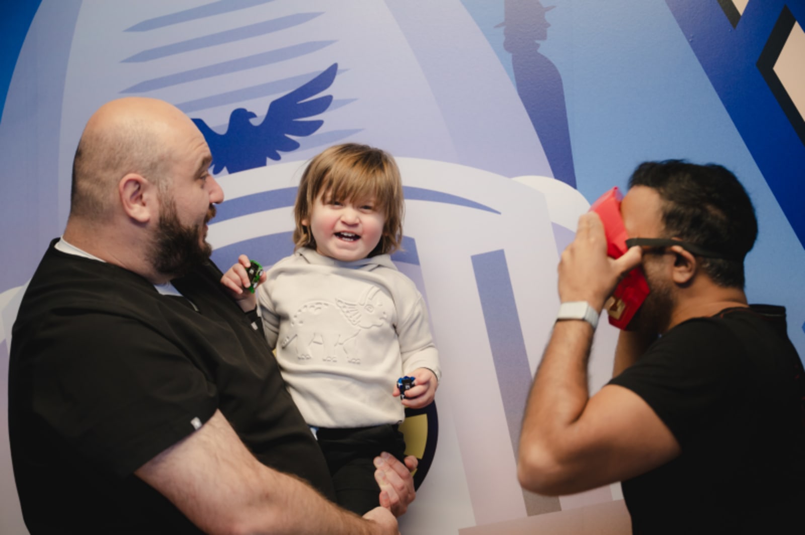 Dentist and dental team member interacting warmly with a toddler during a dental visit